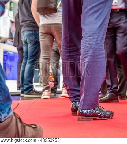 Low Section Of Businessman And Womans Legs Walking On Red Carpet