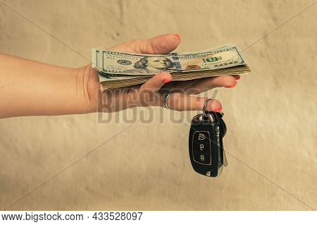Dollars And Black Car Keys In A Womans Hand.
