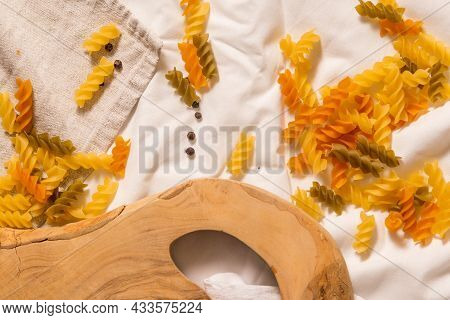 Fragment Of Cutting Board Curved Shape Of Olive Tree, Scattered Around Pasta, Garlic, Pepper. They L