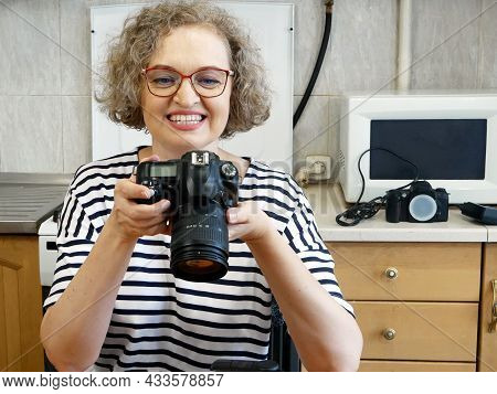 Woman Photographer Making Her Blog About Photo And Video Camera In Kitchen, Lens And Flash Equipment