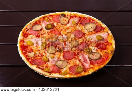 A Whole Rustic Pizza With Brisket, Red Onion, Gherkins, Salami, Mozzarella Cheese, Jalapeno Pepper