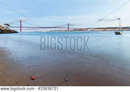 The 25 De Abril Suspension Bridge Over Tagus River In Lisbon, Portugal At Sunrise