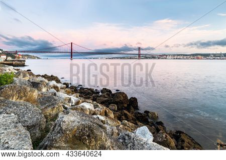 The 25 De Abril Suspension Bridge Over Tagus River In Lisbon, Portugal At Sunrise
