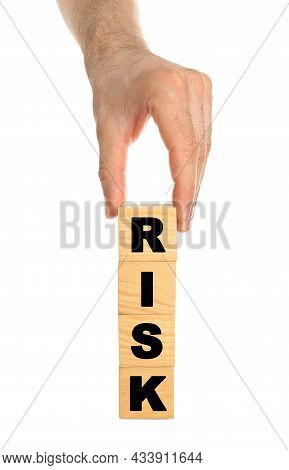 Man Stacking Wooden Cubes With Word Risk On White Background, Closeup