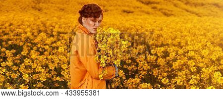 Portrait Of Red Haired Women Dressed In Trendy Fall Orange Trench Coat In Colourful Orange Field. Fa