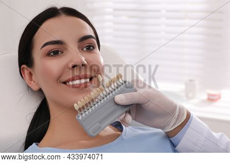 Dentist Checking Young Woman's Teeth Color In Clinic