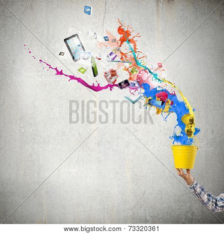 Close up of hand splashing colorful paint from bucket