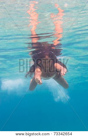 Young woman swimming undewater in the sea