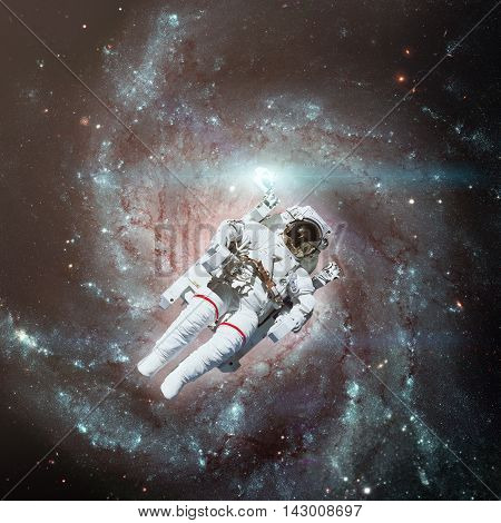 Astronaut in outer space. Spiral galaxy on the background. Elements of this image furnished by NASA.