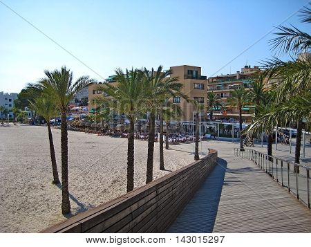 Alcudia Majorca Spain - June 26 2008: At the beach with hotels - view from bridge - surrounded by palms.
