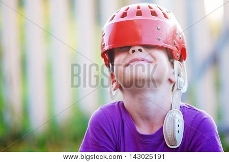 child wears old hockey helmet and having fun. old hockey helmet slid the eye of a laughing boy