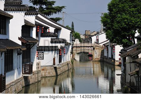 White tradional chinese buildings lining a water canal in Luzhi town in Jiangsu province china.