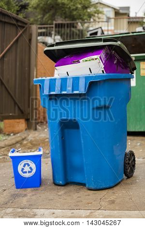 Full recycling bin waits to be dumped.