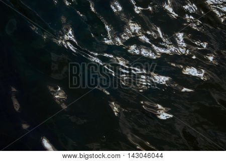 Reflections in the water with small waves. Abstraction texture background