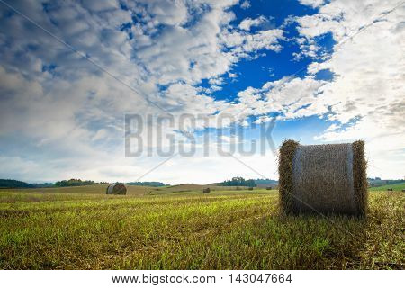 Haystack on a field of stubble. August countryside landscape. Masuria Poland.