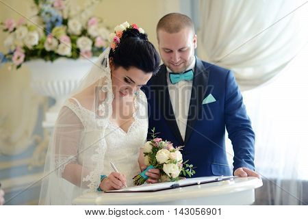 Beauty Bride And Handsome Groom Are Registering The Marriage. Wedding Couple Is Marrying. Beautiful