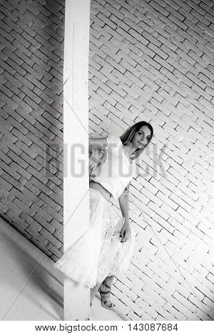 Girl sit on stairs on brick wall baclground
