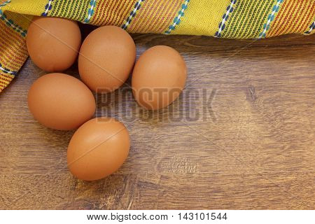 Raw eggs on a wooden background top view.