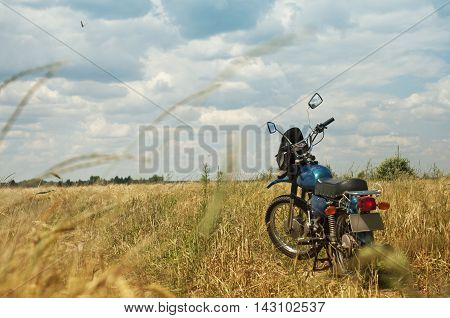 Bike on the road in the rye field in a bright summer day