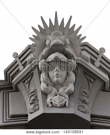 Carved facade element with a face and rays on an old building in Riga
