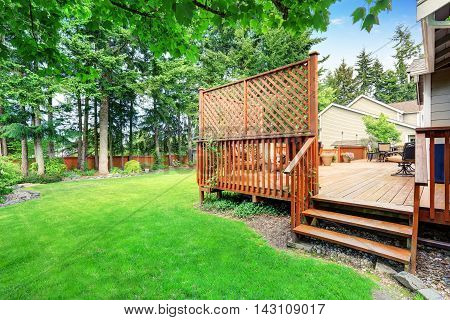 Spacious Wooden Deck With Patio Area And Attached Pergola.