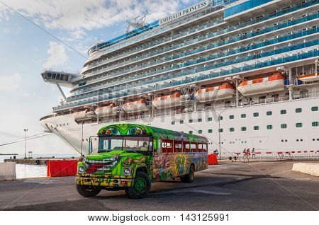 Oranjestad Aruba - December 01 2011: A Princess Cruise Line cruise ship Emerald Princess docked in Oranjestad. A colorful tour bus waiting for the next group of tourists for a fun island tour.