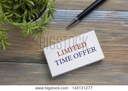 Text Limited time offer on white paper book and office supplies on wooddesk. Business concept