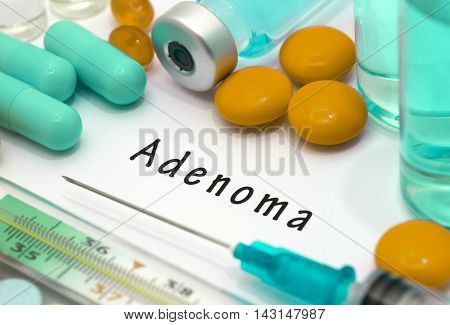 Adenoma - diagnosis written on a white piece of paper. Syringe and vaccine with drugs.