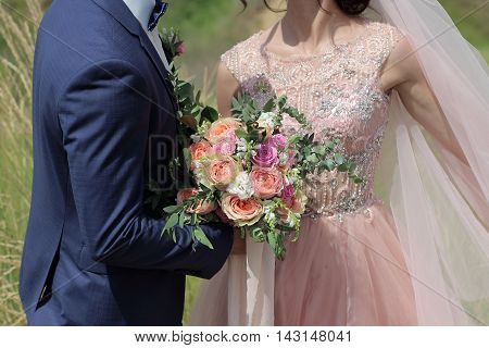 Beautiful bridal bouquet in hands of the bride. Wedding bouquet of peach roses by David Austin single-head pink rose aqua eucalyptus ruscus gypsophila