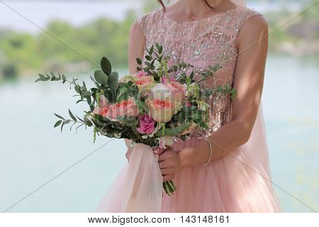 Beautiful bridal bouquet in hands of the bride. Wedding bouquet of peach roses by David Austin single-head pink rose aqua eucalyptus ruscus gypsophila