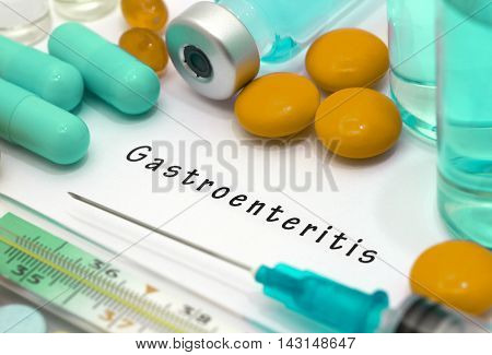 Gastroenteritis - diagnosis written on a white piece of paper. Syringe and vaccine with drugs