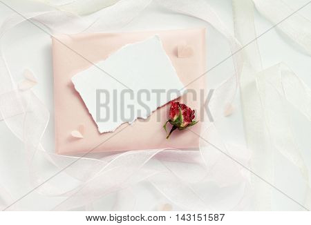 Dreamy delicate congratulation background. Pale pink paper handmade gift, empty card, dried rose, ribbons decor. Top view above, light airy mock-up.