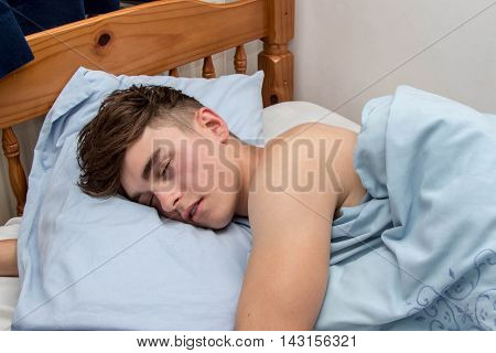 Teenage boy fast alseep in his bed