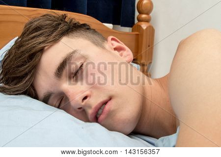 Teenage boy fast alseep in his bed