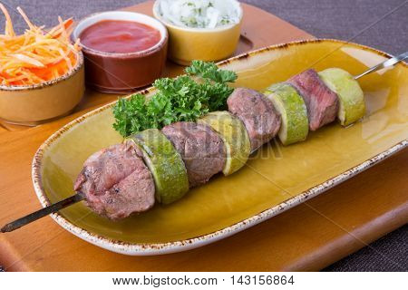 Grilled kebab meat with zucchini on metal skewer