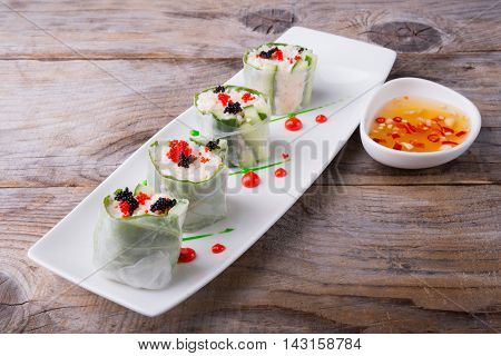 Spring roll with caviar cucumber and cili sauce