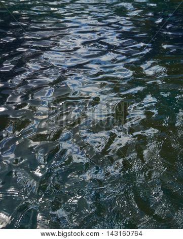 Reflections in the water with small waves. Abstraction texture background