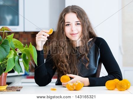 The Young girl is eating an orange