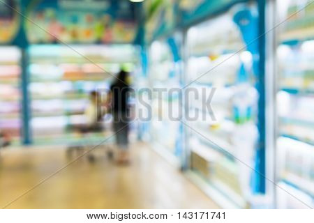 Blurred of baby on shopping cart with mother in supermarket. with baby safty sign on shoping car
