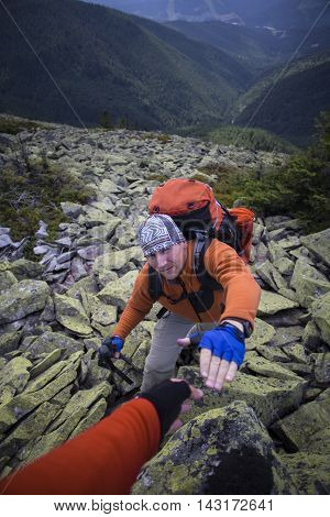 Mountain instructor handed someone a helping hand to the top of the mountain.