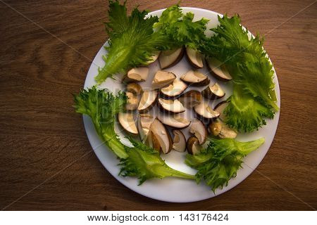 mushrooms and salad on a white plate on the table