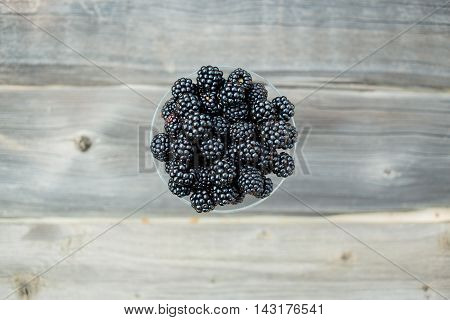 organic blackberries in a glass on a gray wooden board, rustic, detox, selective focus