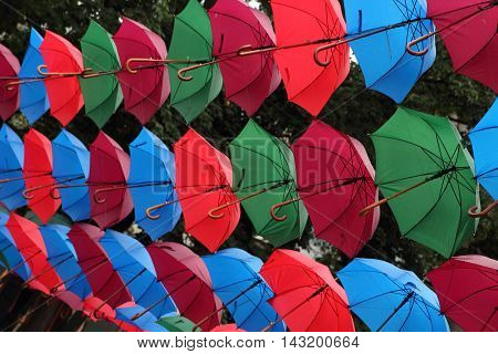 Many colorful umbrellas on the street weighs