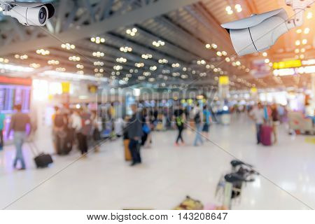 Closeup CCTV security camera on blurred inside the airport terminal background.