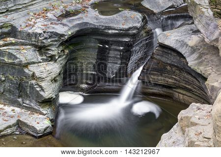 Water carves a narrow channel through layerd rock in the gorge at New York's Watkins Glen State Park.