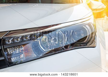 Closeup headlights of modern white car with LED daylight running lights