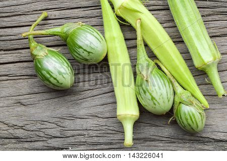 fresh green eggplant and Okra on wooden floor