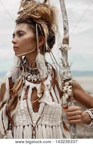 Attractive wild boho woman in white tribal dress portrait