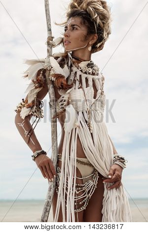 Attractive wild boho woman at beach. Native american style