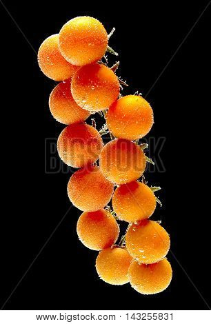 Tomato in water on black background with drops